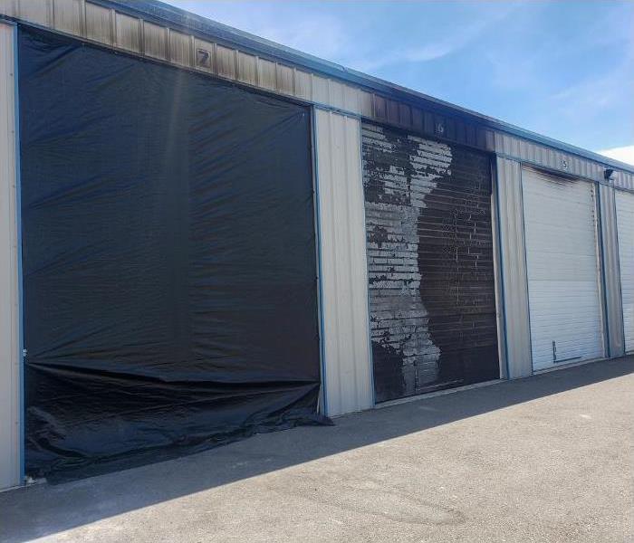 warehouse, large garage doors, covered in soot after a commercial fire