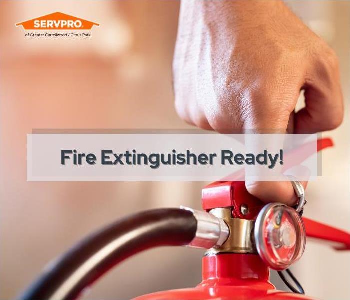 fire extinguisher, man's hand on the pin of a flame extinguisher near me in Tampa Southeast, SERVPRO of Tampa Southeast logo 