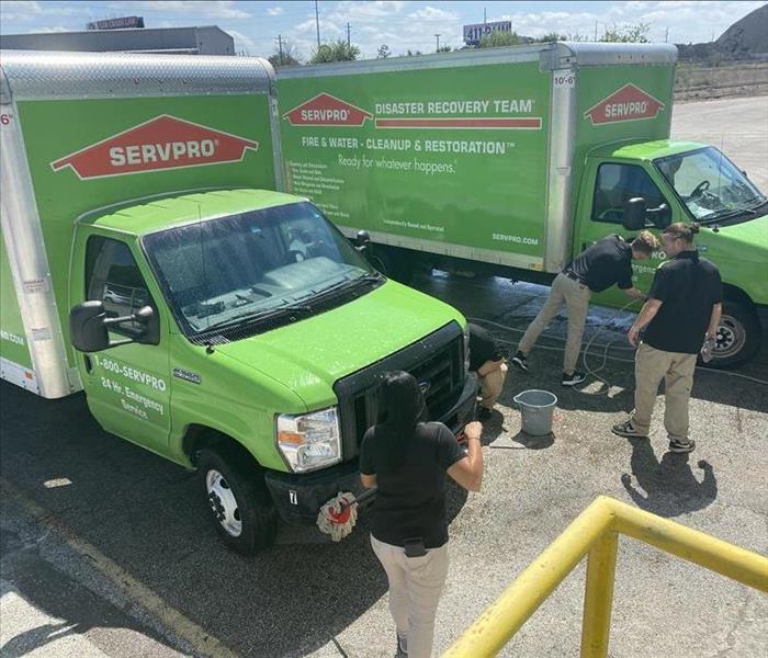 picture of employees cleaning SERVPRO vehicles.